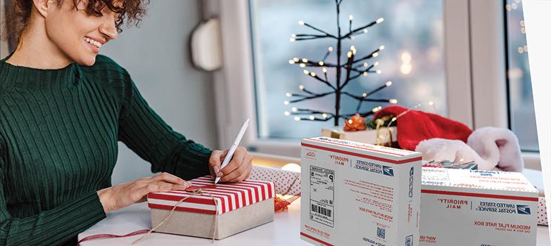 People wrapping holiday gifts they'll ship inside Priority Mail<sup>®</sup> boxes.